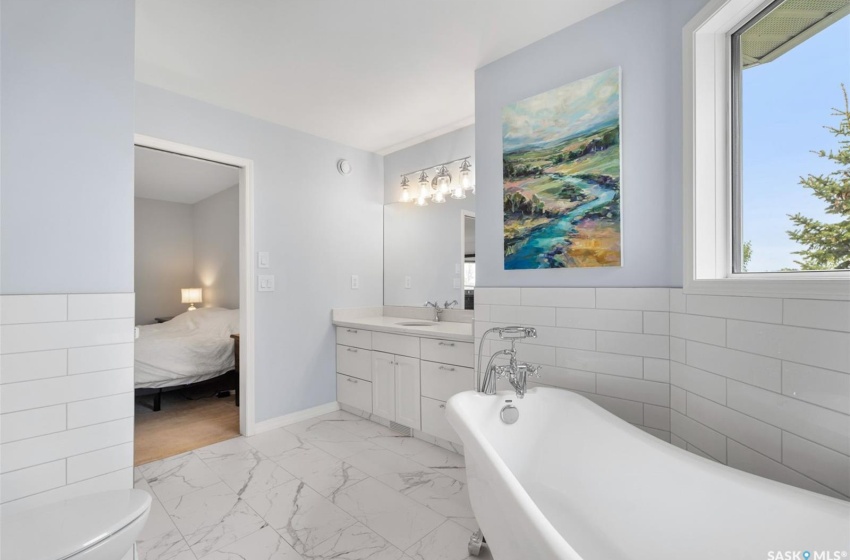 Bathroom featuring vanity, toilet, tile patterned flooring, and tile walls