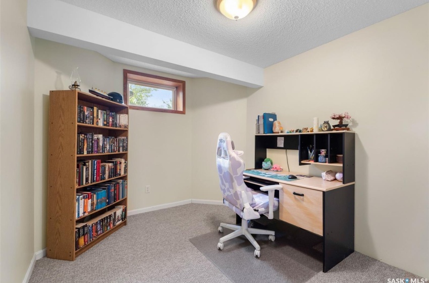 Office space with carpet flooring and a textured ceiling