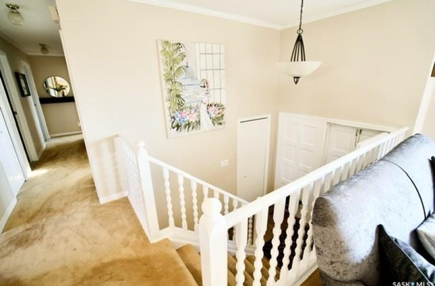 Staircase featuring light carpet and ornamental molding