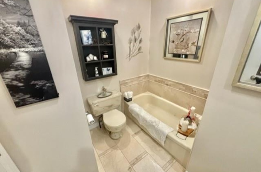 Bathroom with tile floors, toilet, and a washtub