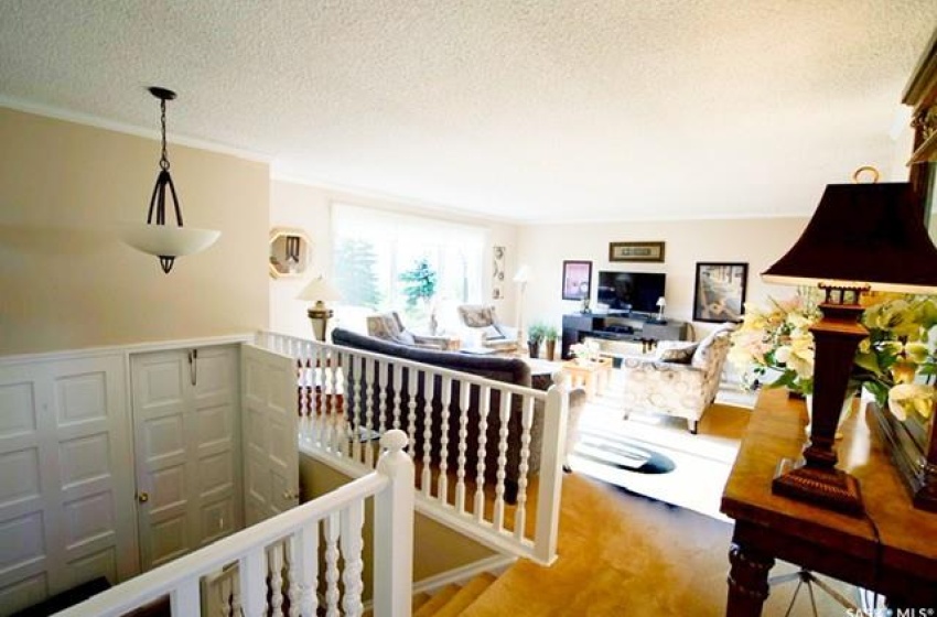 Hallway featuring carpet, a textured ceiling, and crown molding