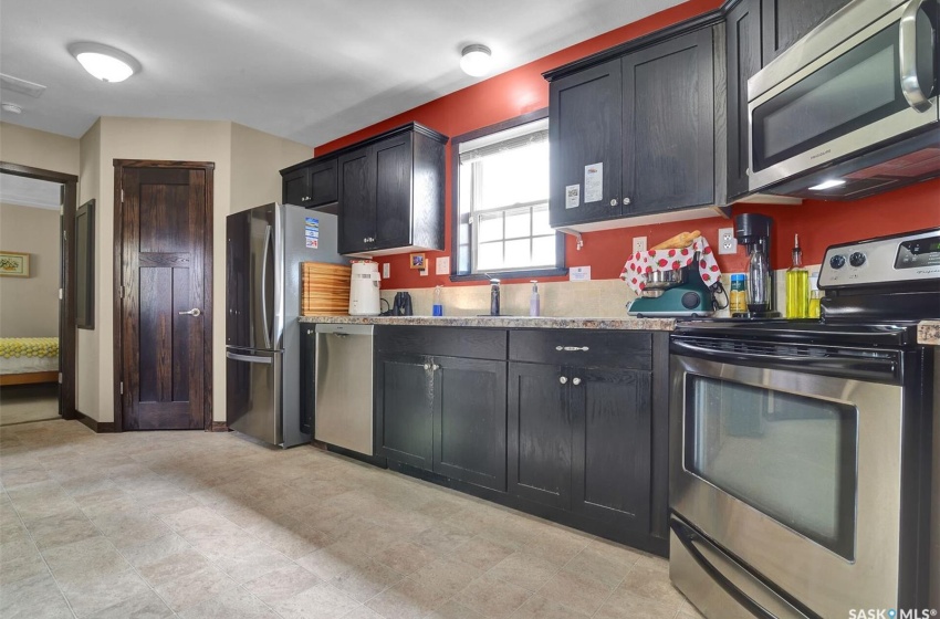 Kitchen featuring sink, light tile floors, and appliances with stainless steel finishes