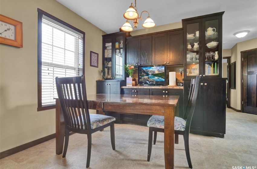 Tiled dining space featuring a healthy amount of sunlight and an inviting chandelier