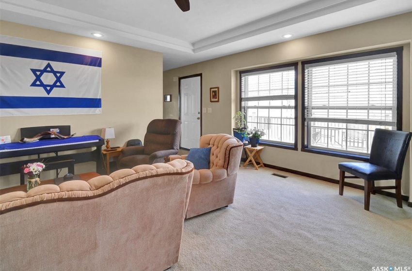 Carpeted living room featuring a raised ceiling