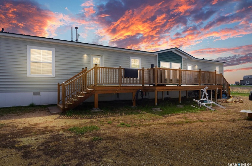 Back house at dusk featuring a deck