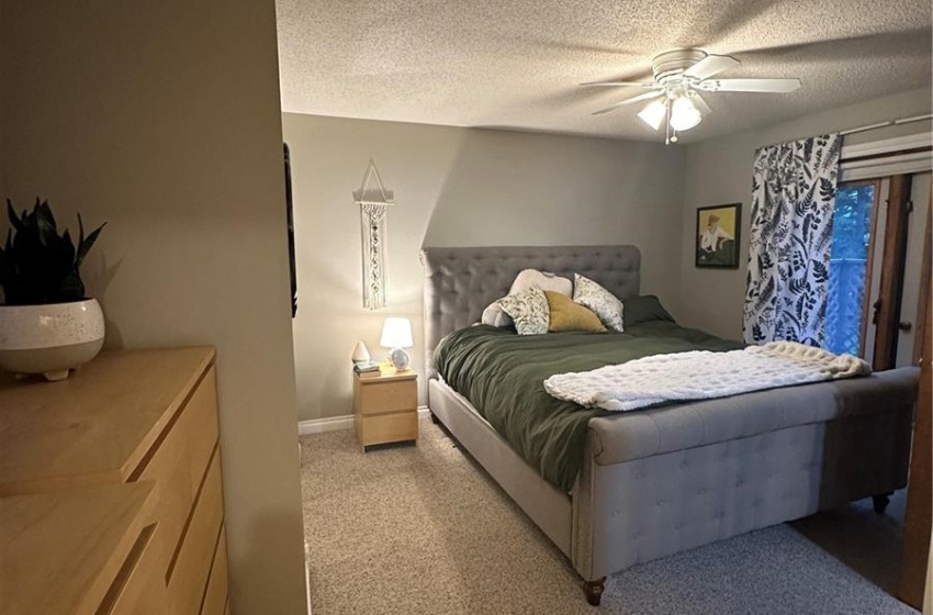 Bedroom featuring carpet, ceiling fan, and a textured ceiling