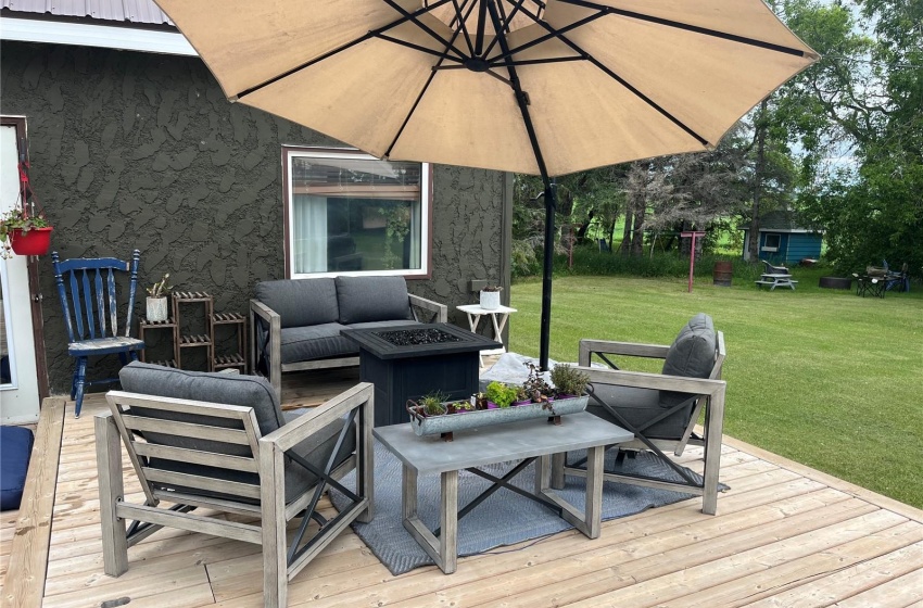 Wooden deck featuring a lawn and an outdoor living space with a fire pit