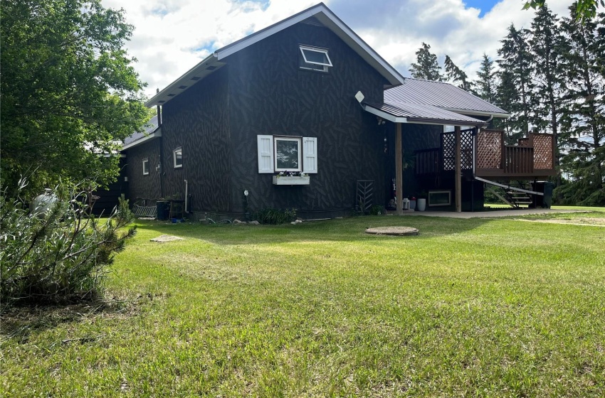 View of side of property featuring a wooden deck and a lawn