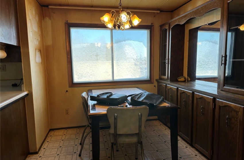 Dining area featuring light tile floors, a notable chandelier, and a healthy amount of sunlight