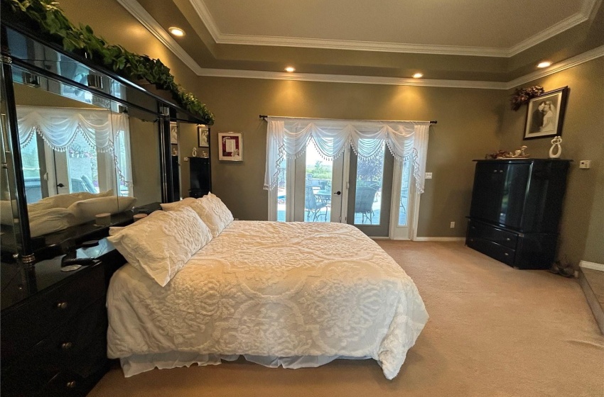 Primary bedroom with 11' ceilings and garden doors to deck & pool