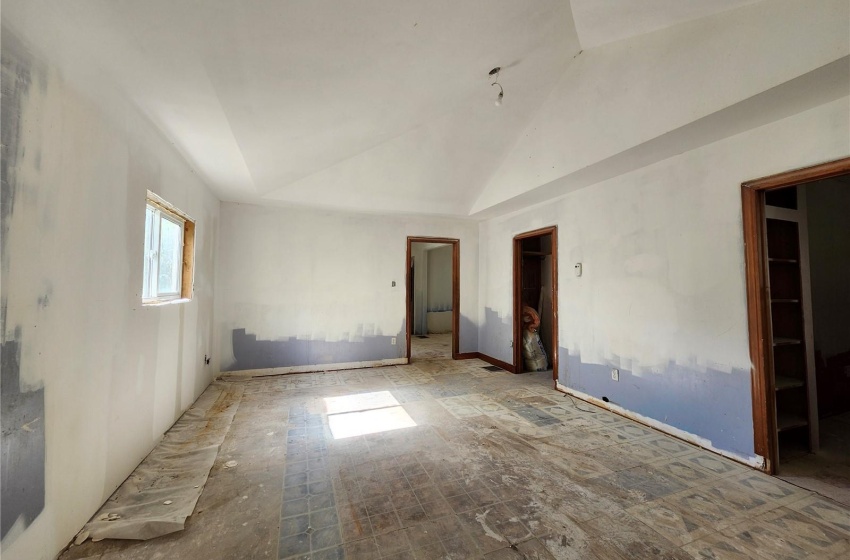 Unfurnished room featuring lofted ceiling