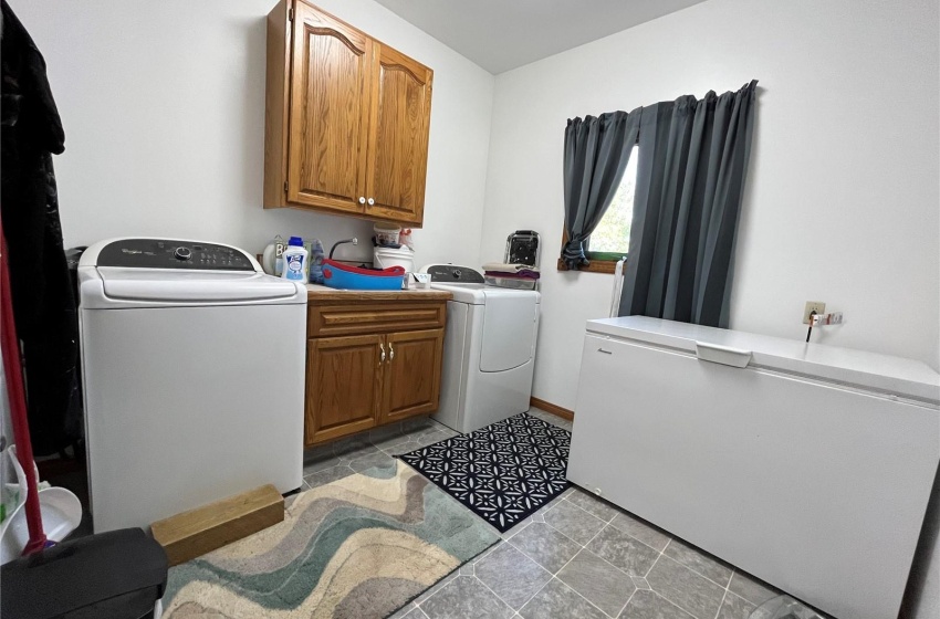 Laundry room featuring washer and clothes dryer, cabinets, and sink