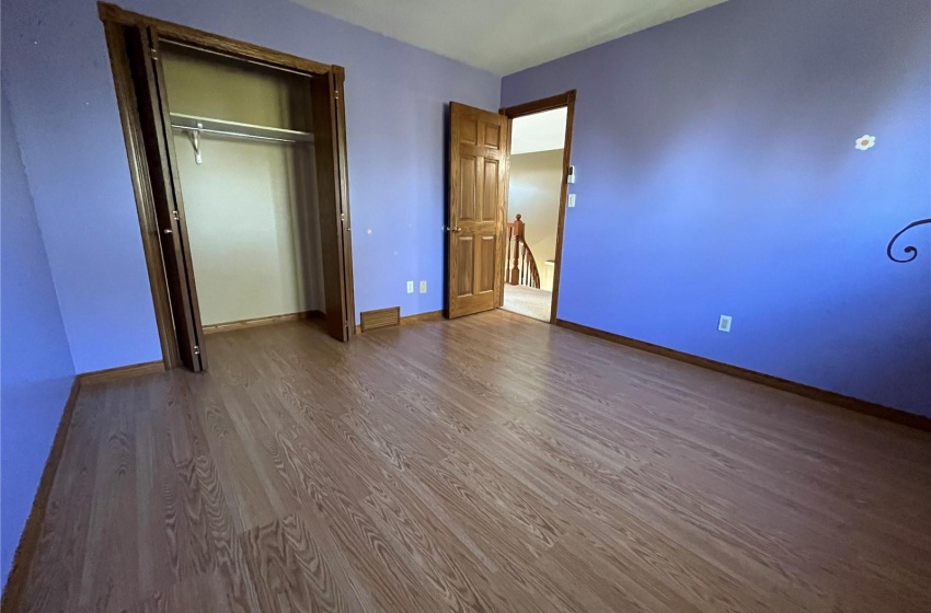 Unfurnished bedroom featuring ceiling fan, a closet, and wood-type flooring