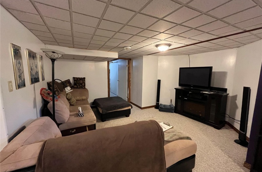 Carpeted living room featuring a drop ceiling