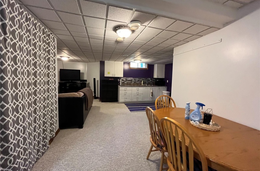 Carpeted dining area with a drop ceiling and sink