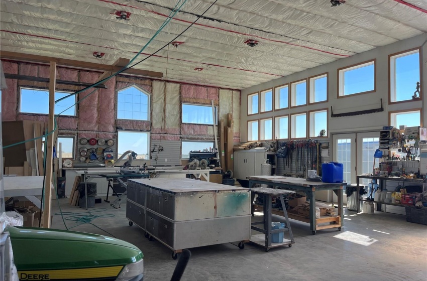 Misc room featuring concrete flooring, a workshop area, and a towering ceiling