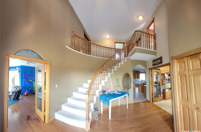 Stairway with wood-type flooring, a high ceiling, and ceiling fan