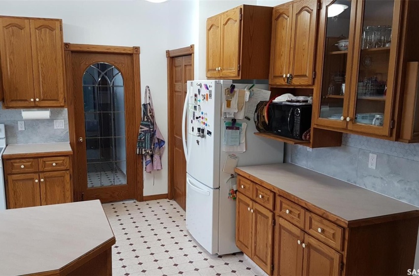 Kitchen featuring backsplash and white appliances