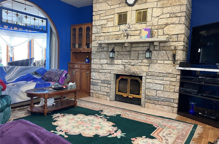 Living room featuring a stone fireplace and light hardwood / wood-style floors