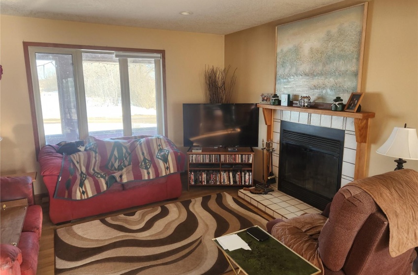 Living room with a tile fireplace and wood-type flooring