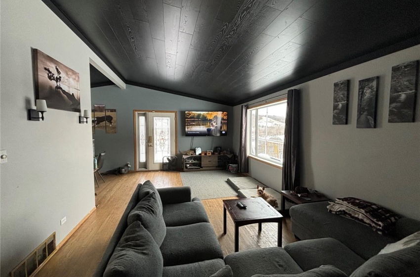 Living room with a healthy amount of sunlight, lofted ceiling, and light wood-type flooring