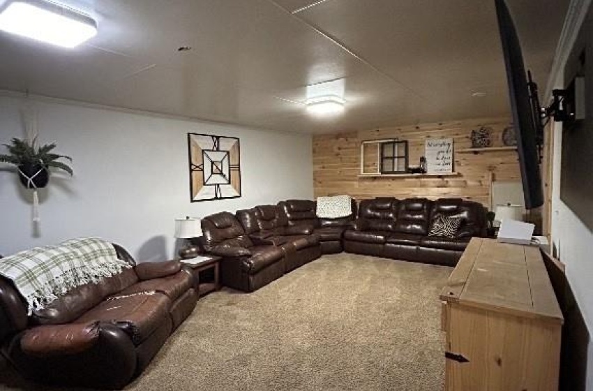 Living room featuring wooden walls, carpet, and a textured ceiling