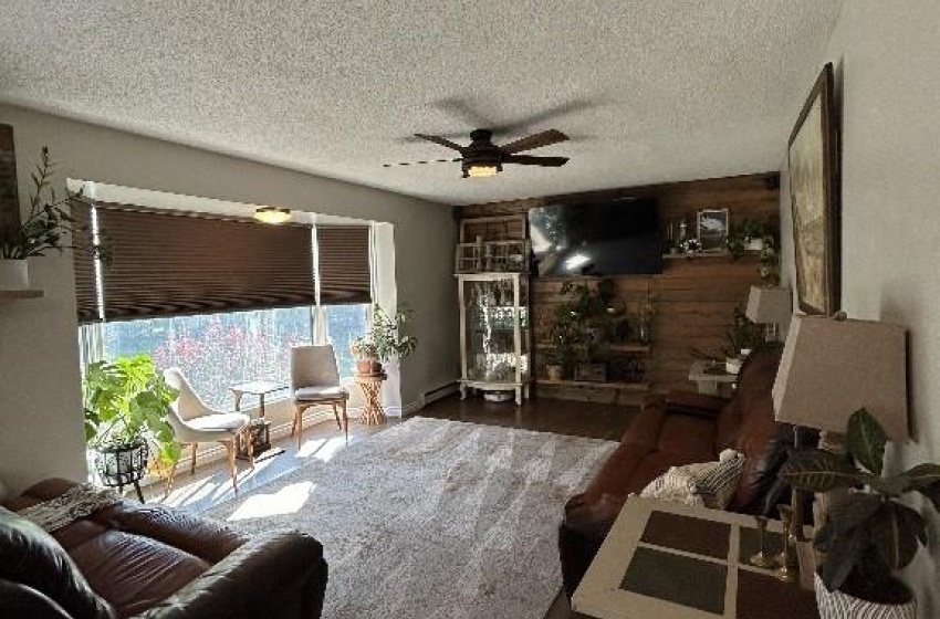 Living room featuring a textured ceiling, dark hardwood / wood-style flooring, and ceiling fan