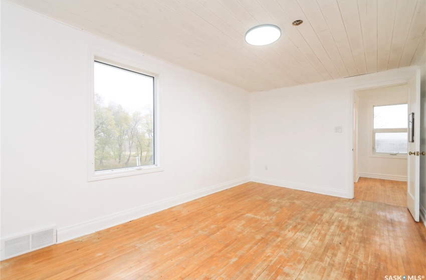 Empty room featuring light hardwood / wood-style floors and wooden ceiling