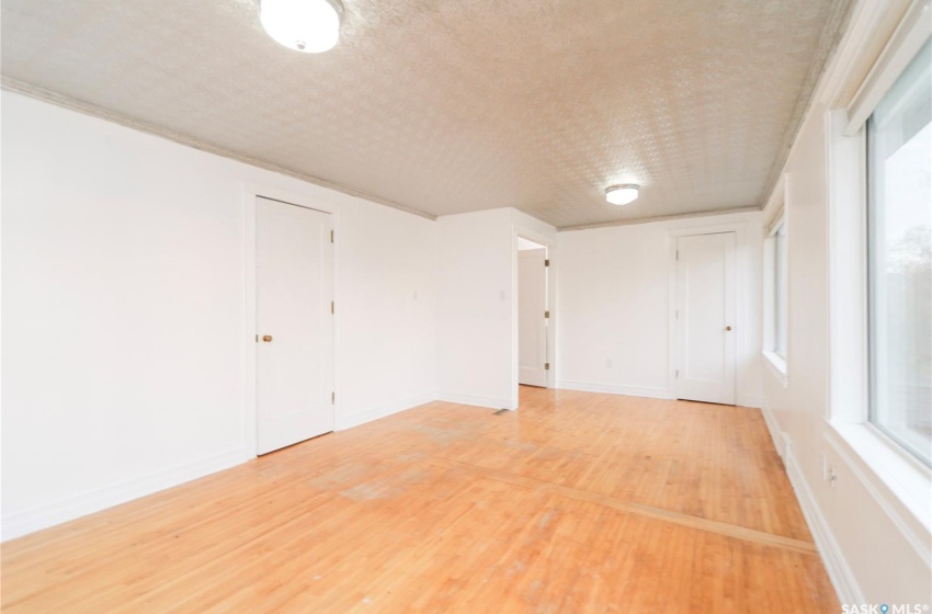 Empty room featuring plenty of natural light, hardwood / wood-style floors, and a textured ceiling