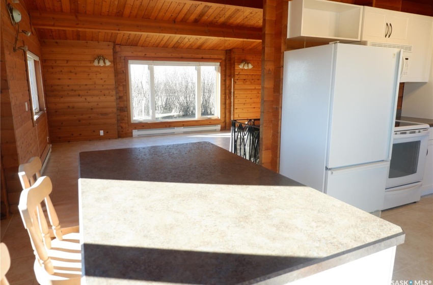 Kitchen featuring white cabinetry, wooden walls, white appliances, wood ceiling, and a baseboard radiator