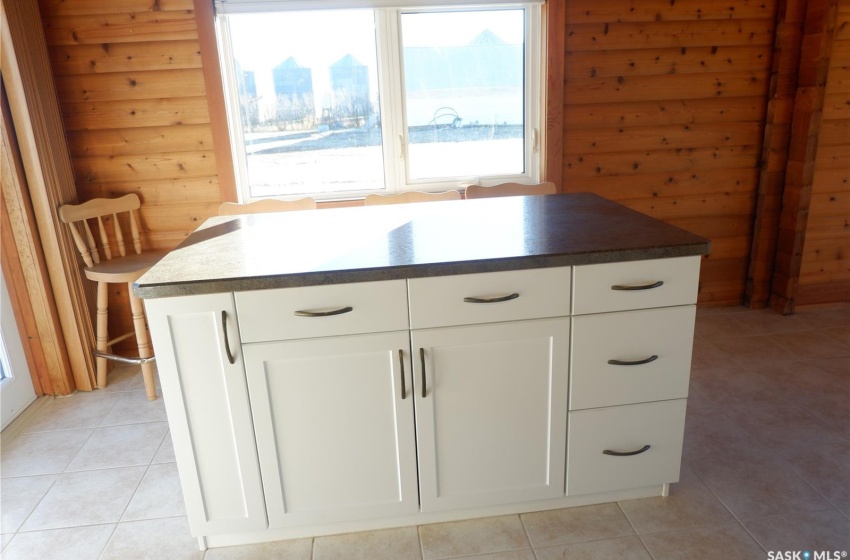 Kitchen featuring white cabinets, light tile patterned floors, and a center island