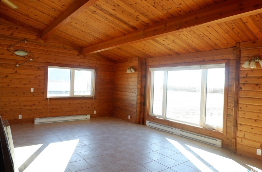 Tiled empty room with lofted ceiling with beams, wooden ceiling, and a baseboard radiator