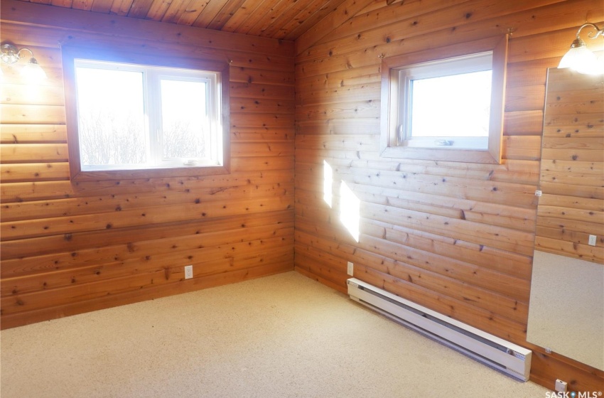 Spare room with carpet flooring, a baseboard radiator, wood walls, and wooden ceiling