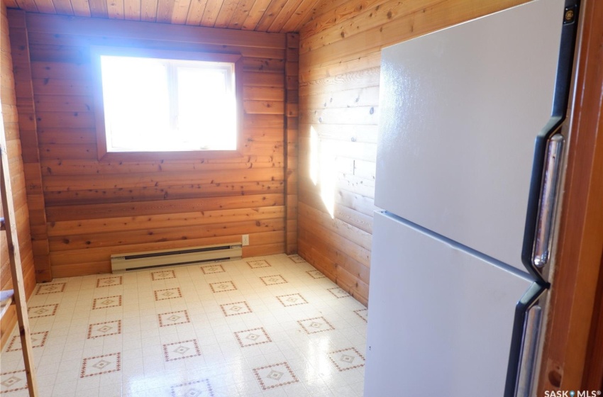 Spare room with a baseboard radiator, wood walls, and wooden ceiling