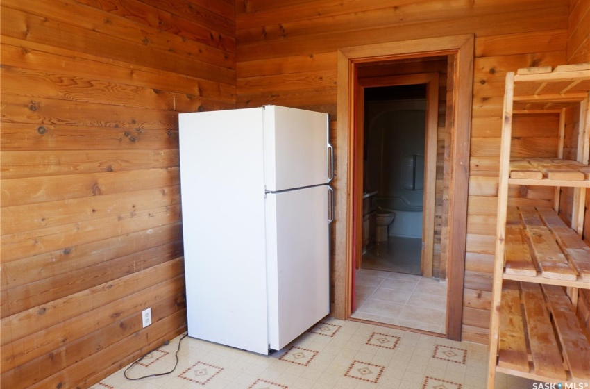 Kitchen featuring wood walls and white fridge