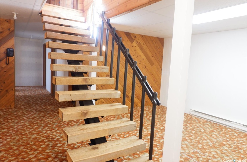 Staircase featuring wood walls