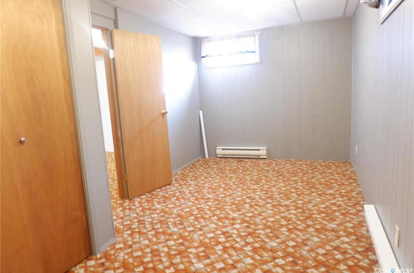 Hallway featuring a baseboard radiator and wooden walls