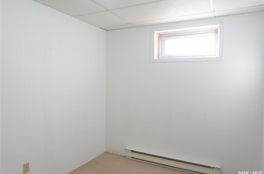 Unfurnished room featuring a baseboard radiator and a paneled ceiling