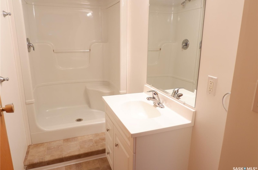 Bathroom featuring walk in shower, vanity, and tile patterned floors