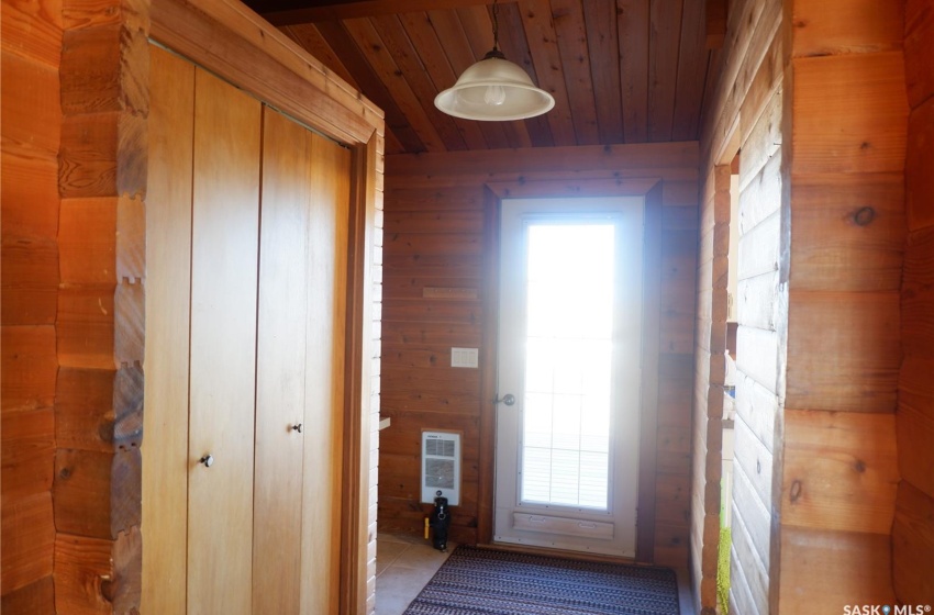 Corridor featuring wooden ceiling, wooden walls, light tile patterned floors, and heating unit