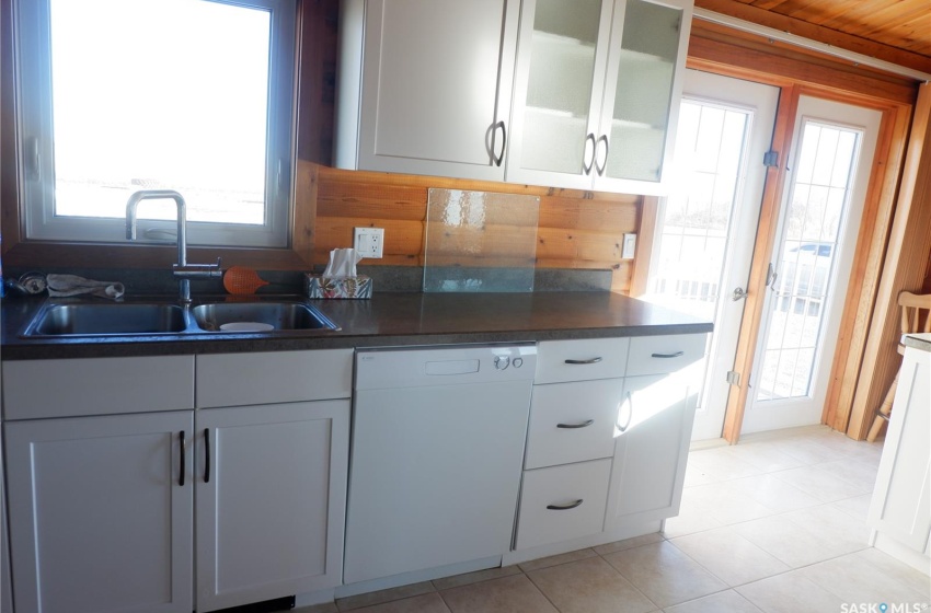 Kitchen featuring dishwasher, sink, wood ceiling, and white cabinets