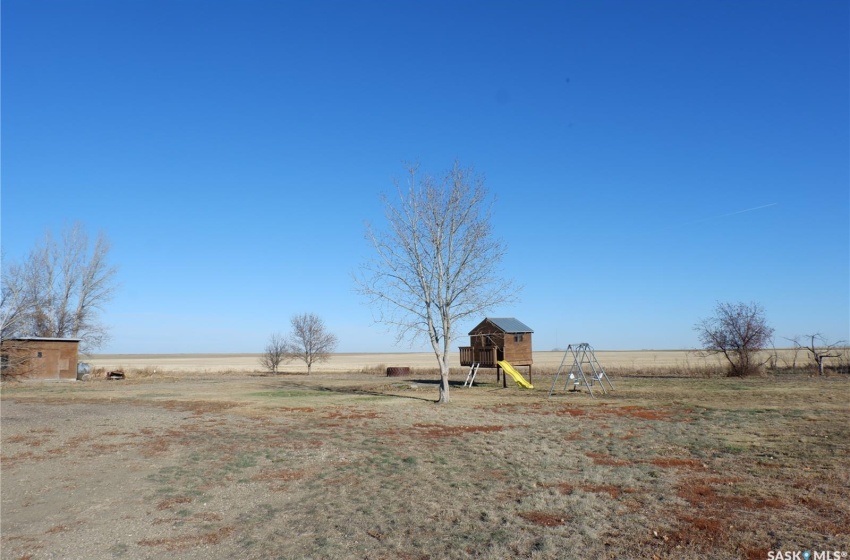 View of yard featuring a playground, a rural view, and an outbuilding