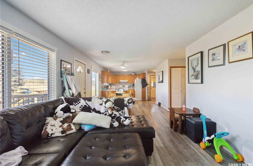 Living room with light vinyl plank flooring and a textured ceiling