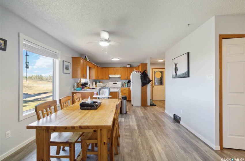 Dining room with ceiling fan, a textured ceiling, and vinyl plank flooring