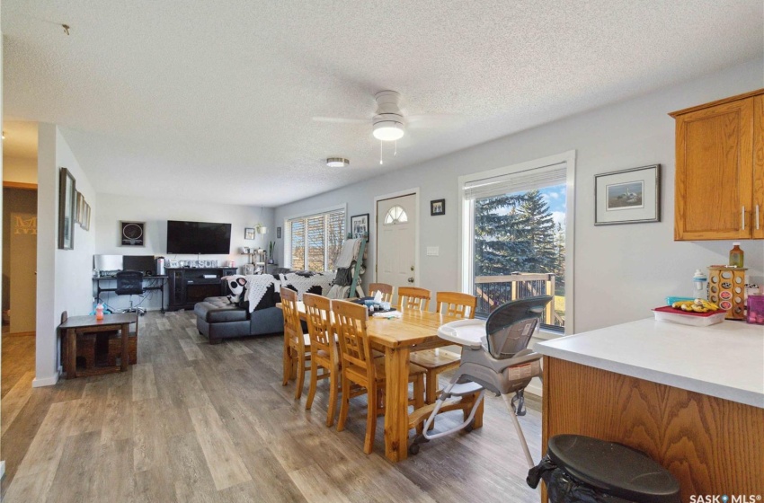 Dining area with a wealth of natural light, a textured ceiling, ceiling fan, and vinyl plank flooring