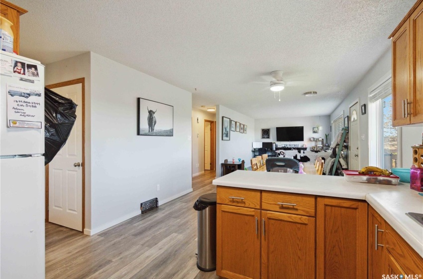 Kitchen featuring ceiling fan, a textured ceiling, white fridge, and vinyl plank flooring