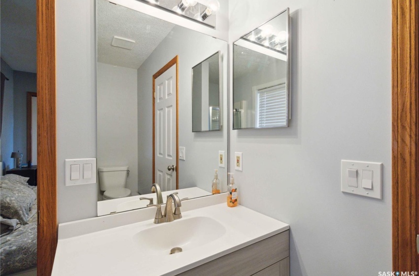 Bathroom with toilet, vanity, and a textured ceiling