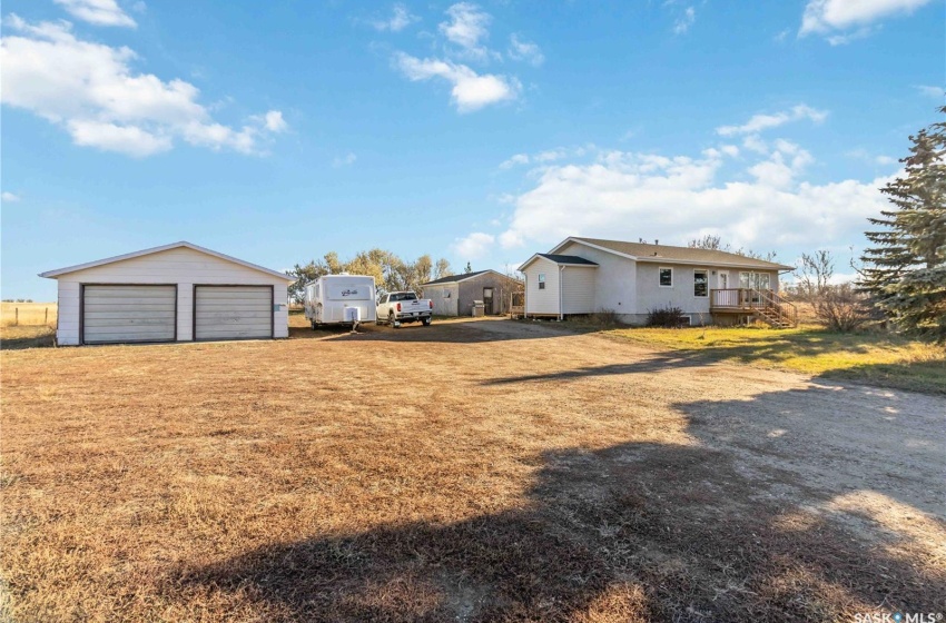 View of yard with a garage, a wooden deck, and an outdoor structure