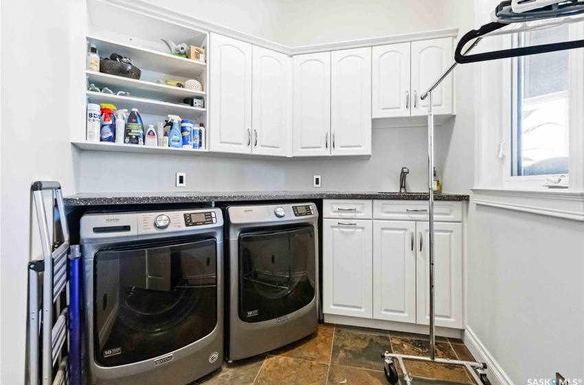 Laundry room featuring cabinets, sink, and washer and dryer