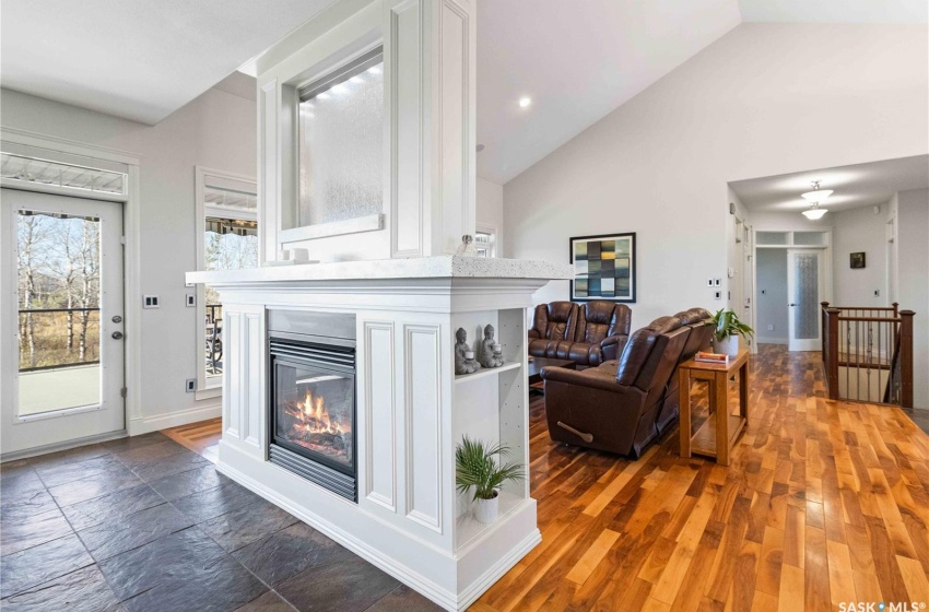 Living room with ceiling fan, dark hardwood / wood-style flooring, and high vaulted ceiling